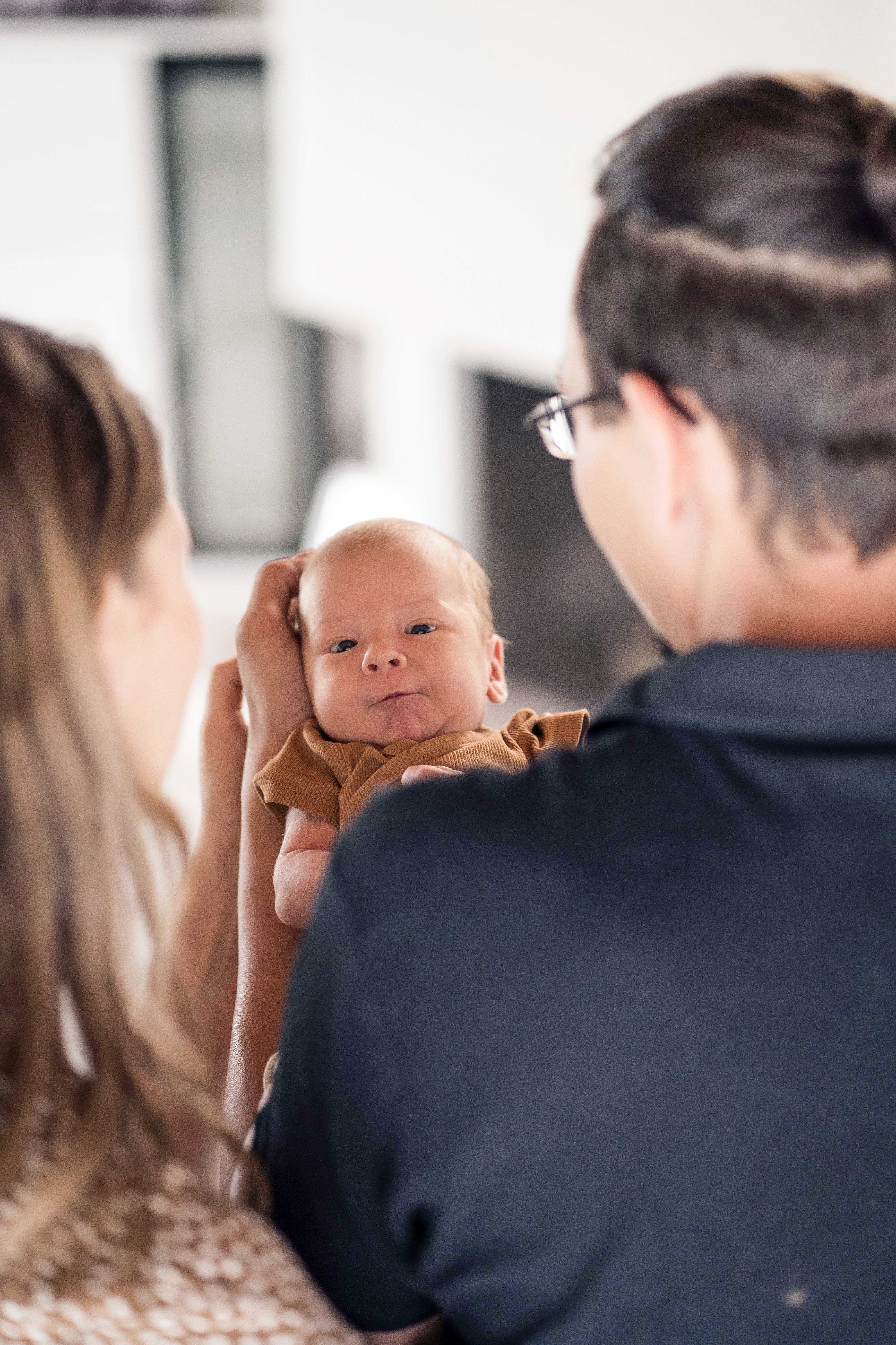 Baby mit dem Rücken der Eltern