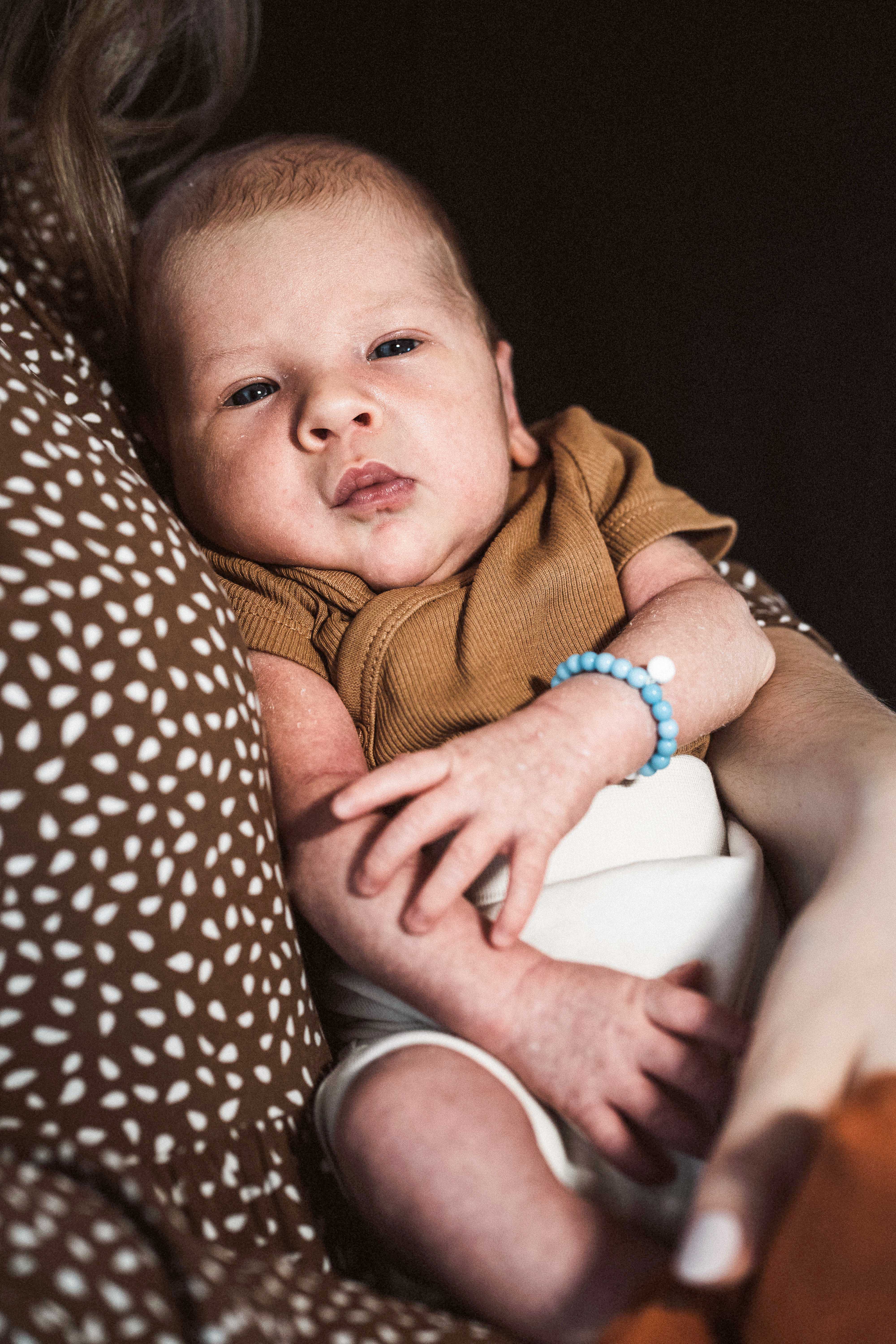 Baby Henry liegt im Arm seiner Eltern