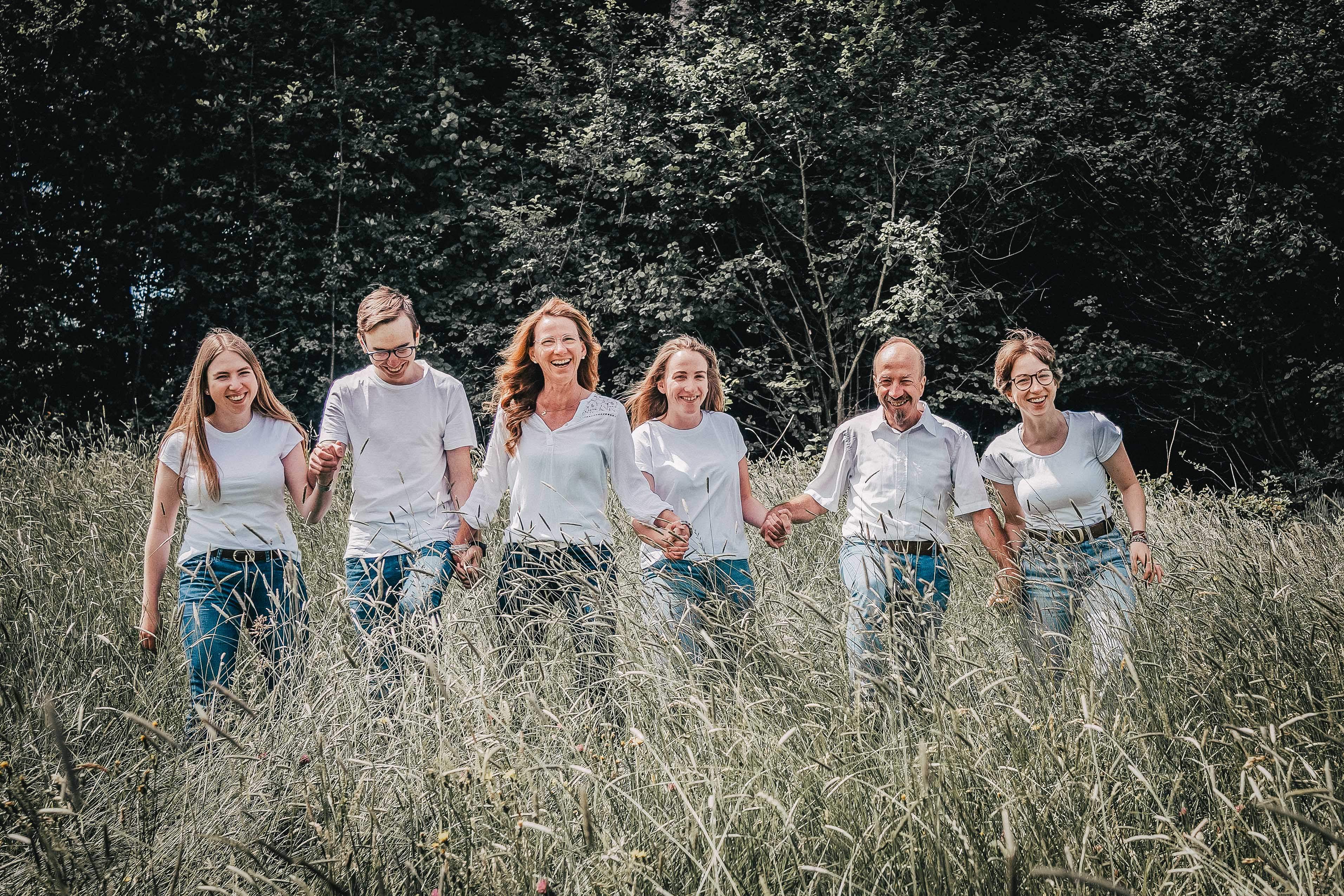 Familie die sich an den Händen hält auf einem Feld