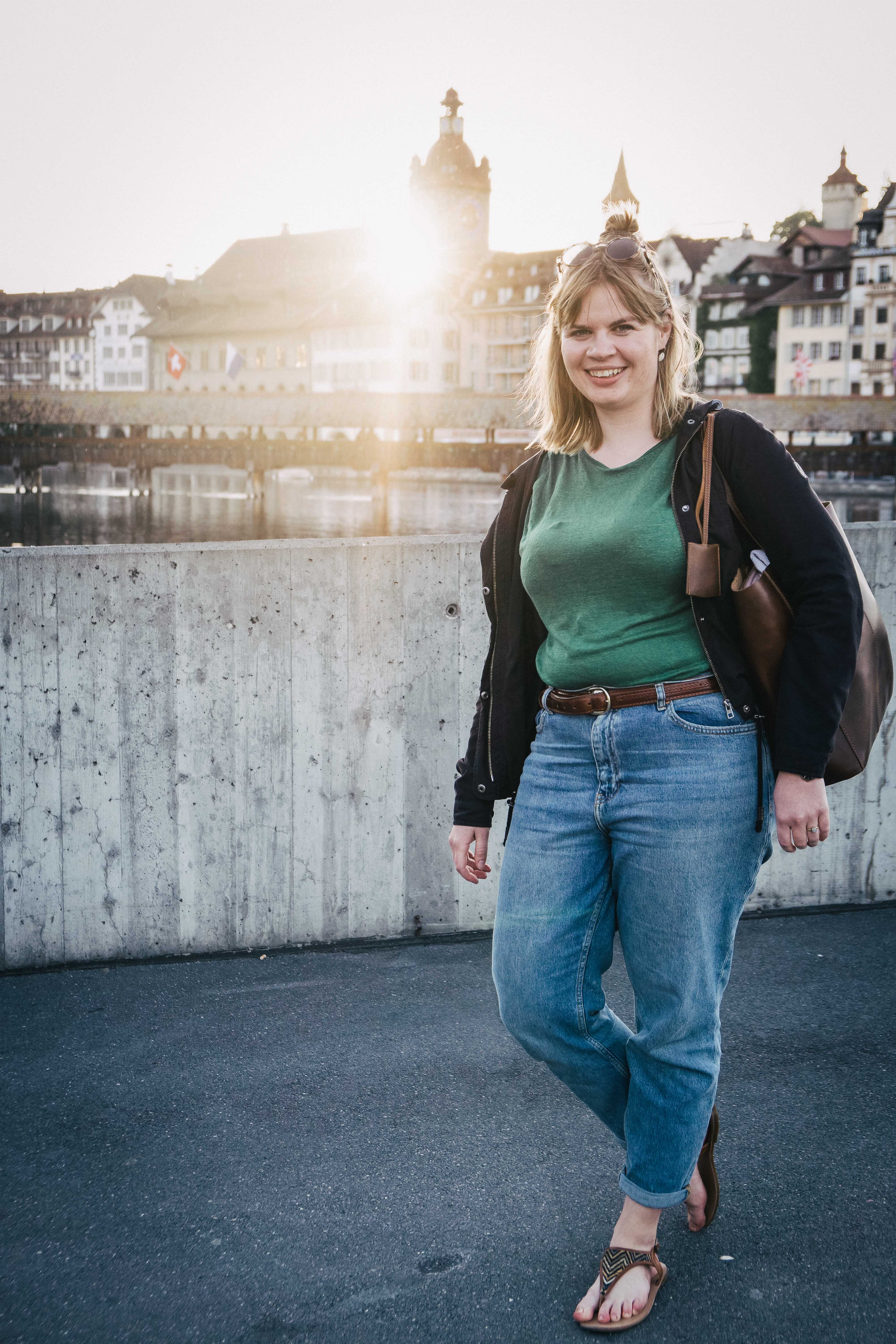 Ganzkörper Portraitfoto einer Frau in der Stadt Luzern bei Sonnenuntergang.