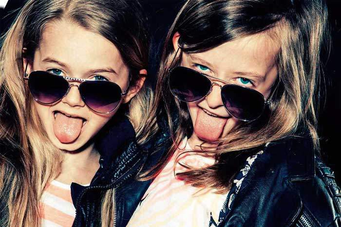 zwei girls mit sonnenbrille strecken die zungen raus